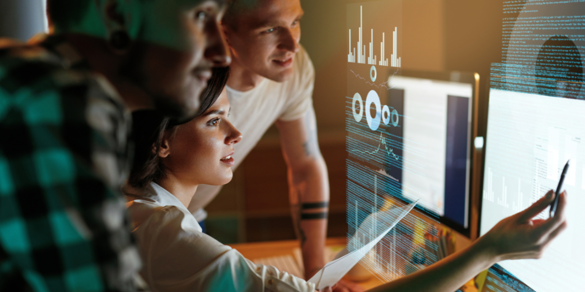 IT professionals reviewing holographic data visualisations and system analytics on transparent display screens in tech workspace