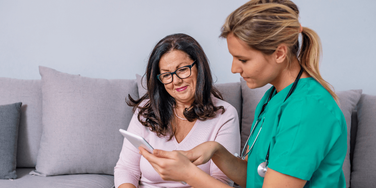 Pitman with NHS medical team assisting elderly patient in hospital corridor