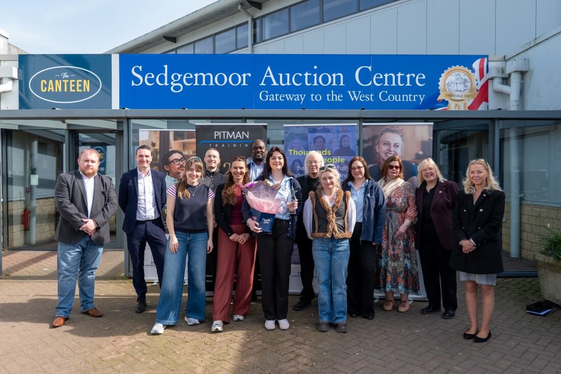 Pitman Training team and students standing outside training centre building at Bromley UK location